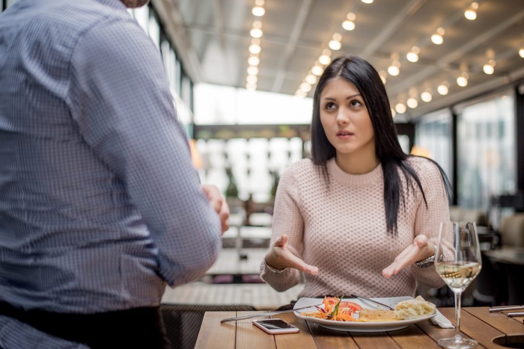 Women look at waiter and pointing at her food