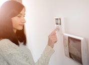 A woman using a keypad for a home security system