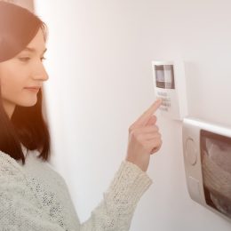 A woman using a keypad for a home security system