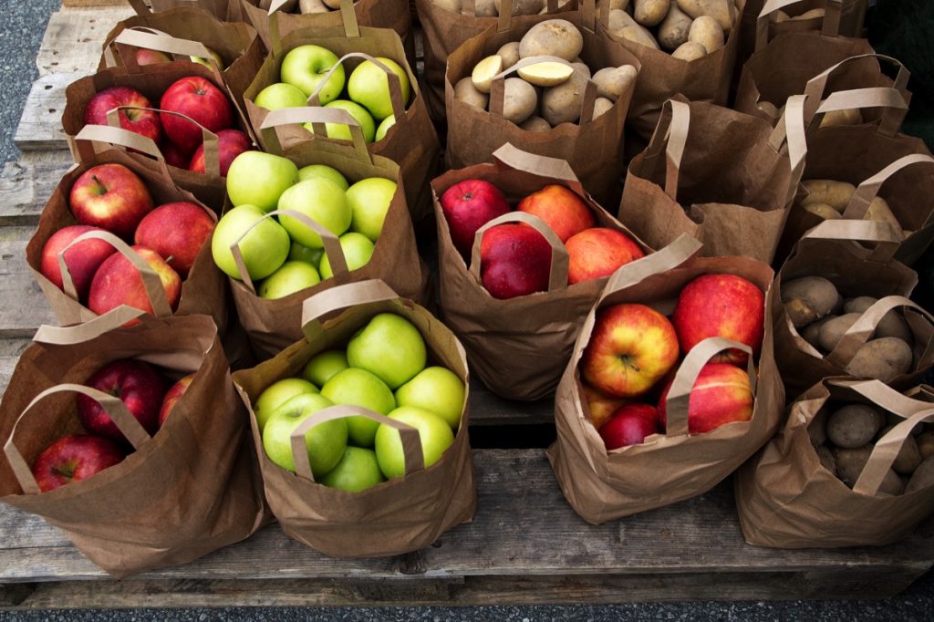 brown paper bags of apples and potatoes