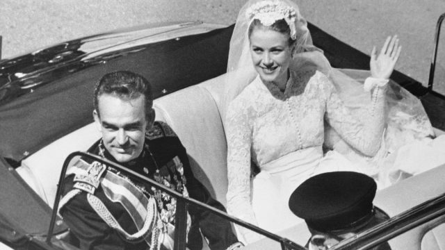 Prince Rainier and Grace Kelly waving to the crowd from an open car after their wedding in April 1956