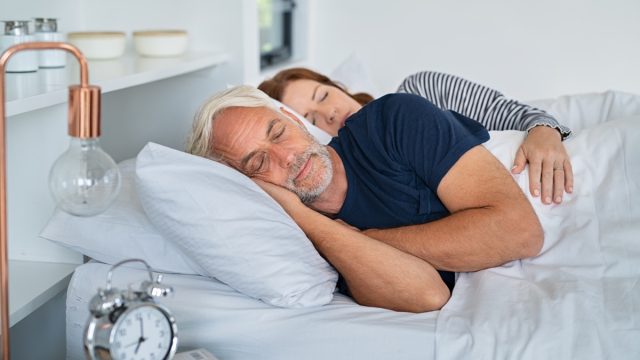 Older couple sleeping in bed