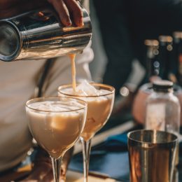 Bartender preparing Irish Cream Liqueur cocktail with shaker
