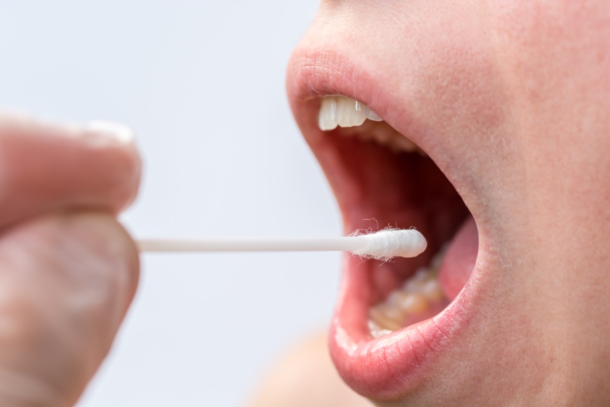 woman swabbing mouth with cotton swab