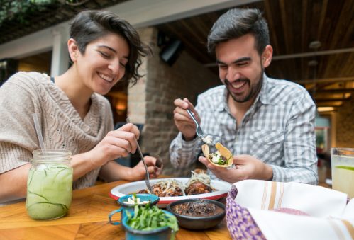 A couple eating tacos at a restaurant