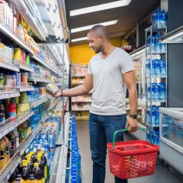 man shopping in beverage section at supermarket.