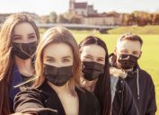 A group of young friends wearing face masks outside