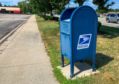 TROY, MICHIGAN - AUGUST 13, 2019: USPS mailbox beside sidewalk