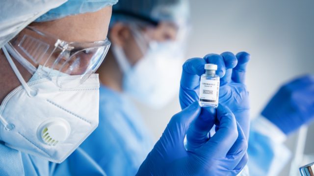 coronavirus covid-19 vaccine bottle in hands of pharmacuetical and vaccine research scientist in laboratory, coronavirus covid-19 vaccine development
