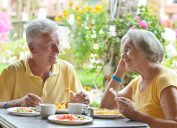older couple eating breakfast outdoors
