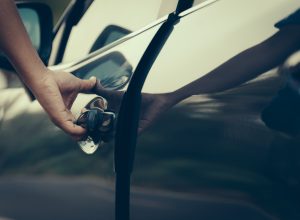 A close up of a person opening a car door