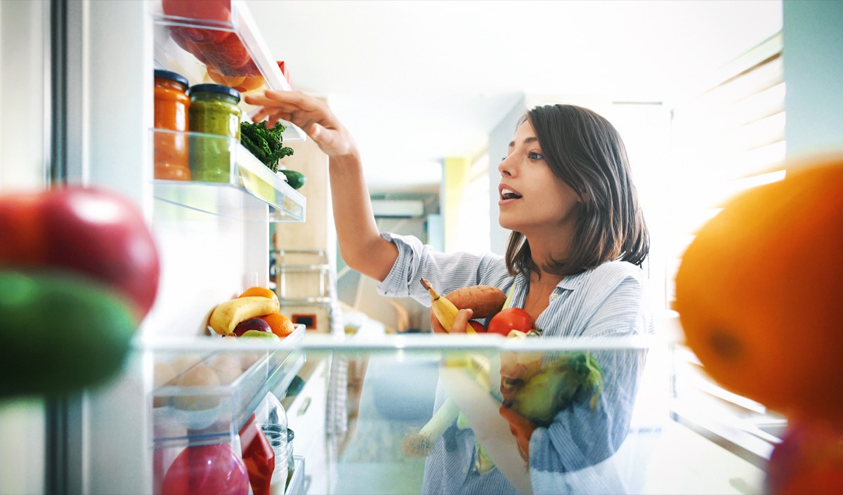 Woman taking produce out of refrigerator
