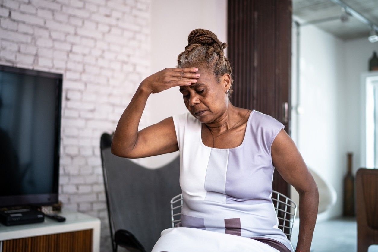 Een oude vrouw die op een stoel zit nadat ze zich duizelig voelt