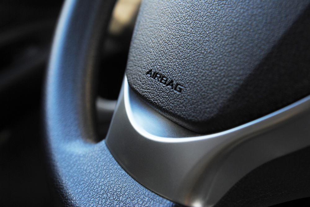 A close up of a steering wheel with an airbag icon