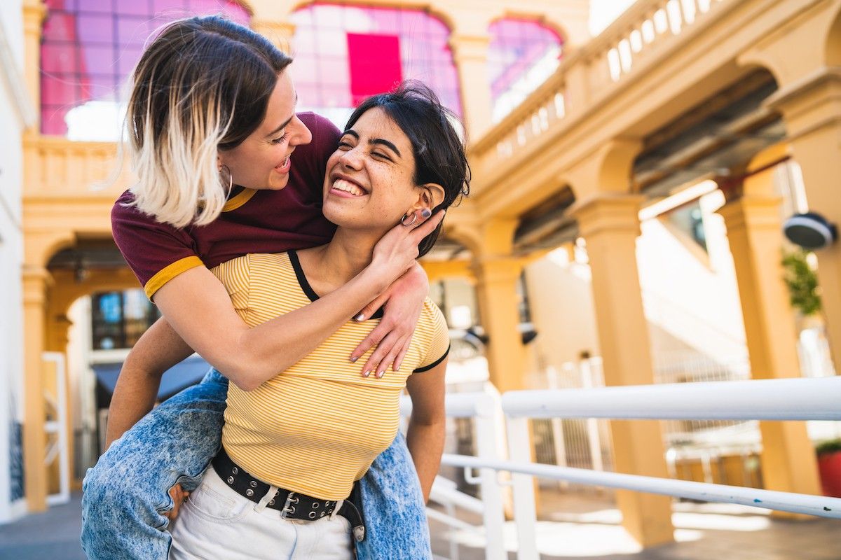 Portrait of lesbian couple spending time together and having fun on the street.