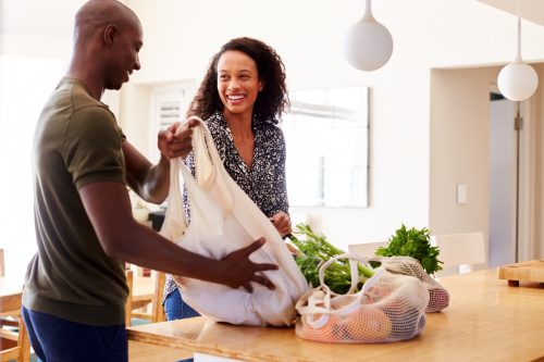 young couple unpacking groceries at home