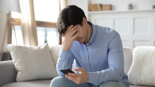 upset man getting call on his smartphone