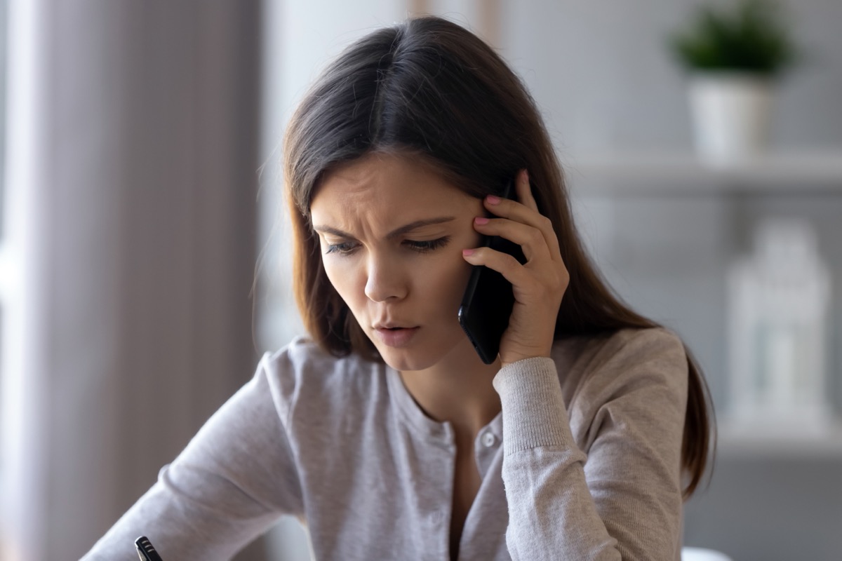 young woman looking upset while making phone call