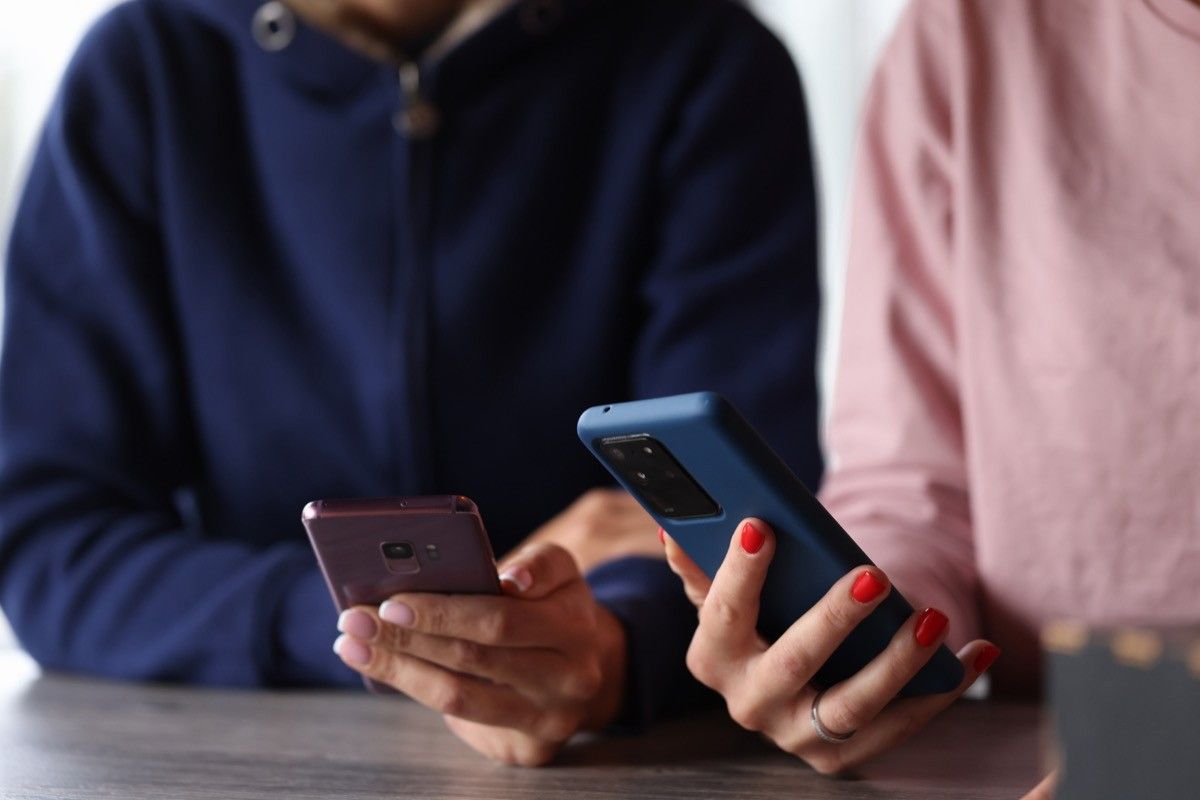 Two women hold smartphones in their hands.  Concept for remote control of smartphones