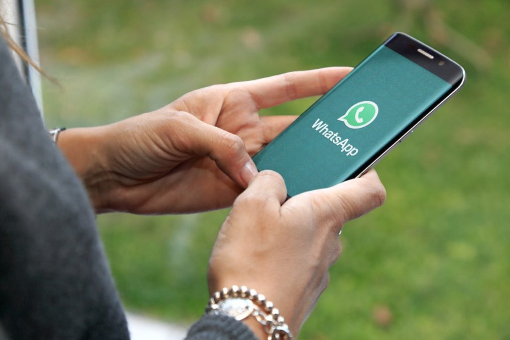 Close up of woman opening WhatsApp on her smartphone