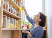 woman reaching for oil in pantry