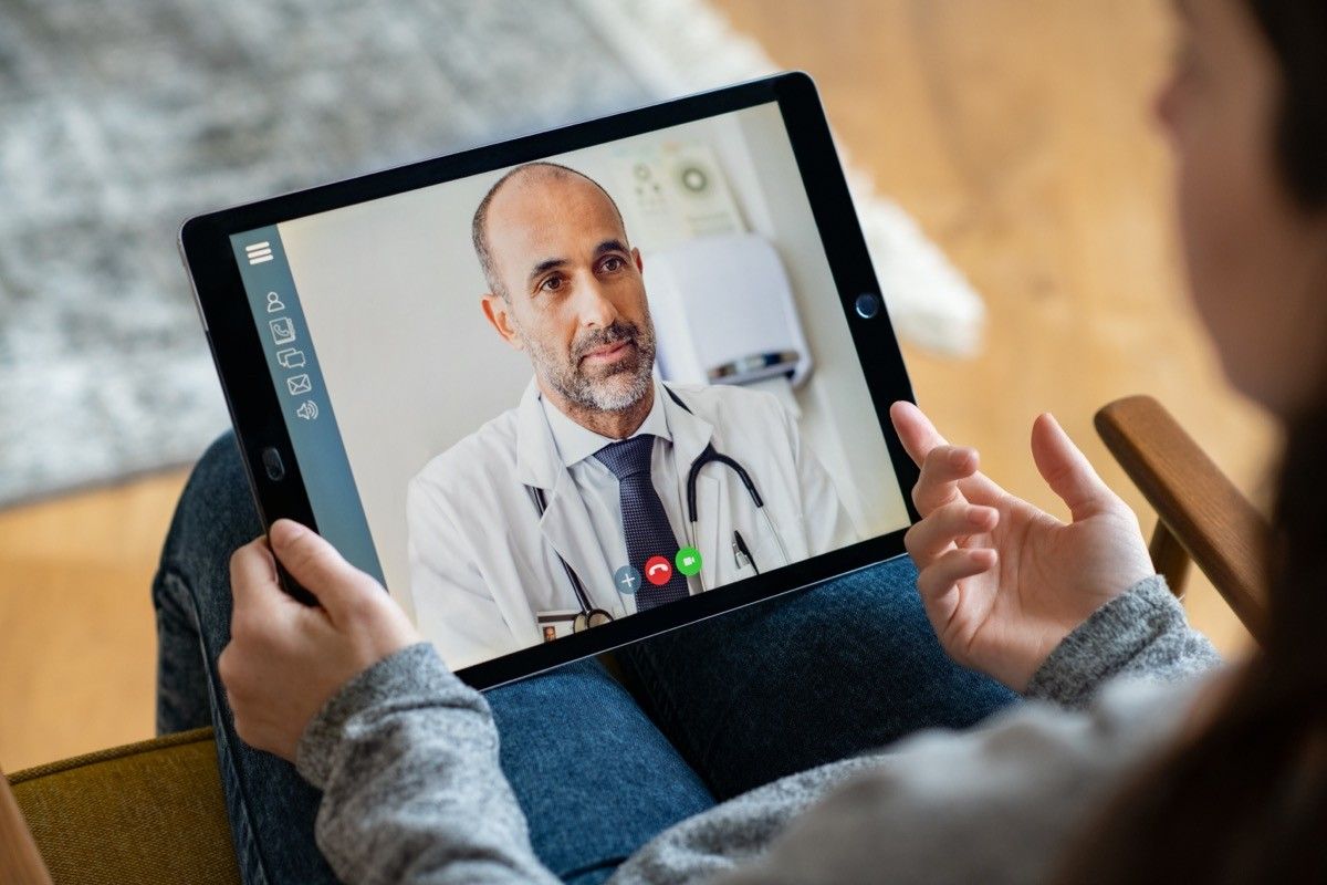 woman visiting television with a male doctor on ipad