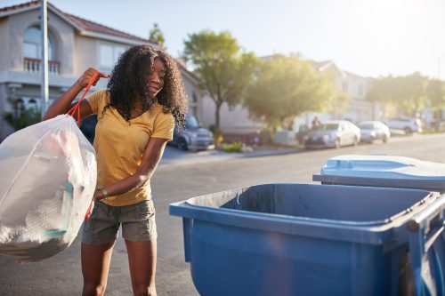 Woman taking out the trash in neighborhood