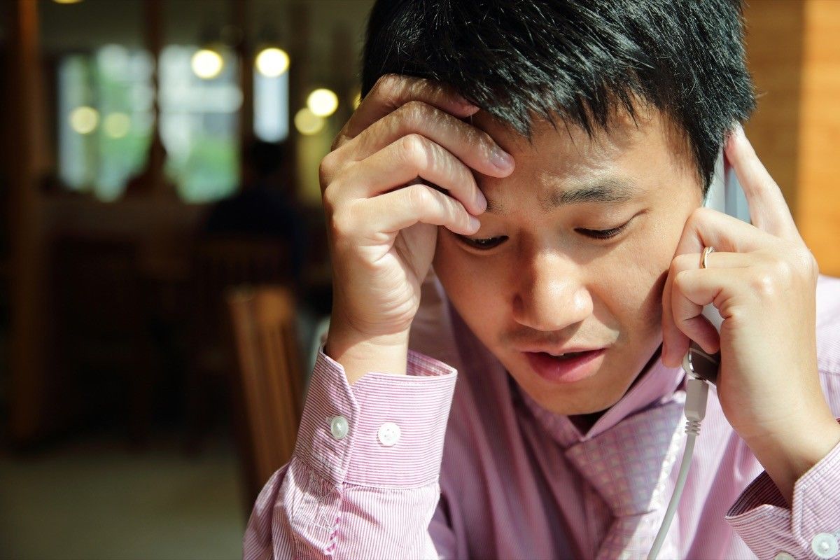 young man looking worried while making phone call