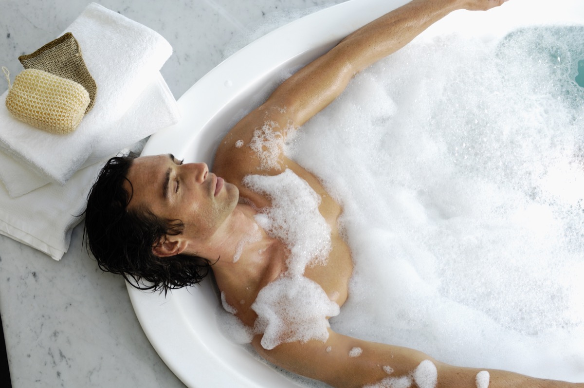 Man laying in bubble bath