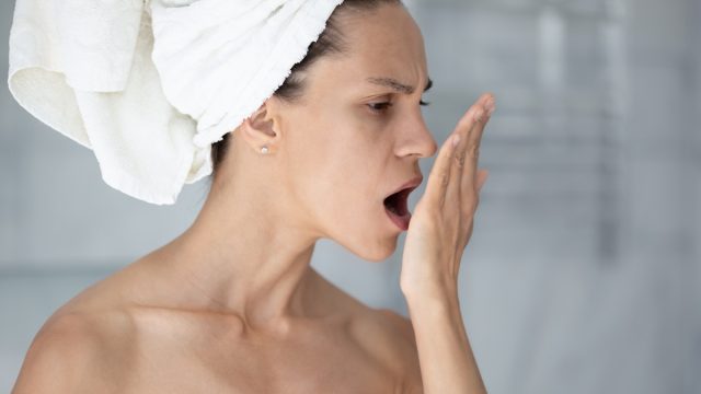 Woman checking her breath after shower