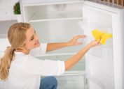 Blonde woman cleaning fridge
