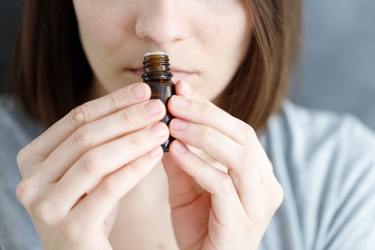 Woman smelling fragrant oil