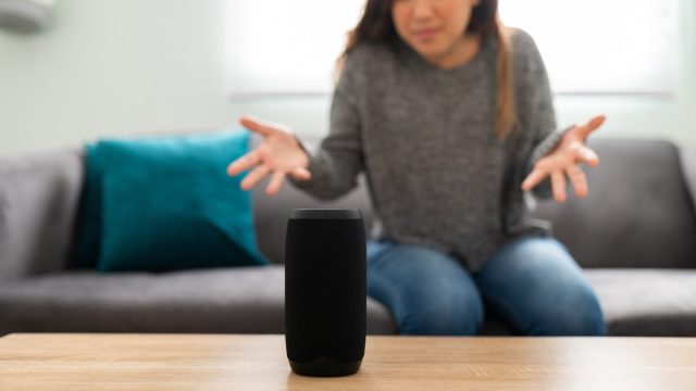 Annoyed woman in her 20s with an angry expression because her smart speaker has an error and is not working
