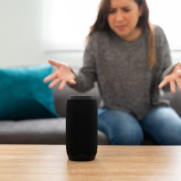 Annoyed woman in her 20s with an angry expression because her smart speaker has an error and is not working