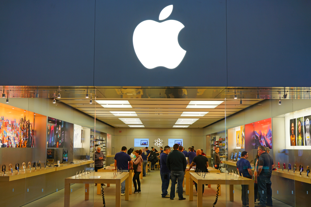 The exterior of an Apple retail store with shoppers and staff inside