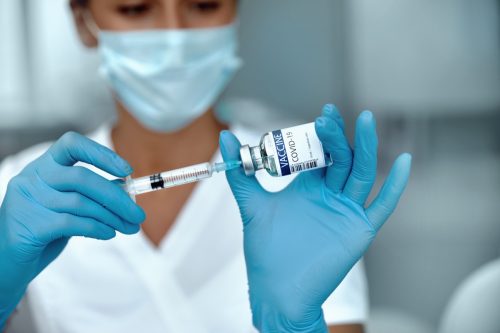 Impfstoffanbieter mit Impfstoffflasche in der Hand
