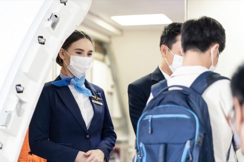Flight attendant greeting passengers