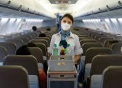 A flight attendant serving drinks on a plane