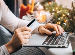 man shopping for holiday gifts online using card