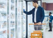 man shopping at supermarket freezer section