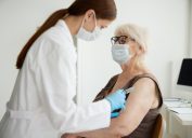 A senior woman receiving a COVID-19 vaccine or booster from a healthcare worker