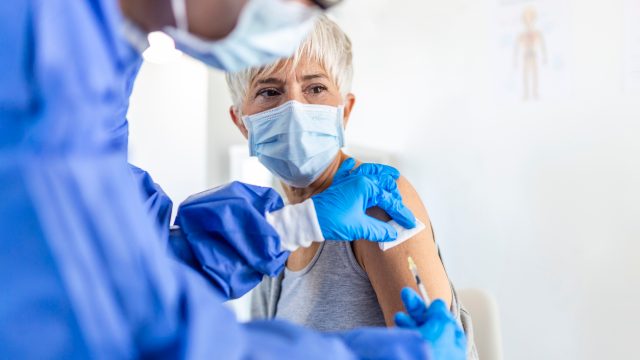A senior woman receiving a COVID-19 vaccine or booster shot