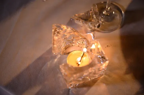 broken glass candle with flame still burning