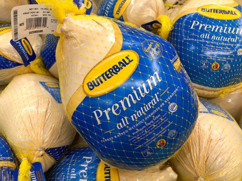 Grocery store freezer shelf with Butterball brand frozen turkeys. The most common main dish of a Thanksgiving dinner.