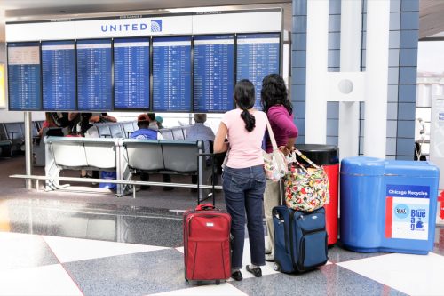 Chicago, Illinois, USA - September 12, 2011: Women at Chicago's O'Hare International Airport read departures list for United Airlines. O'Hare is one of the busiest airports in the world.