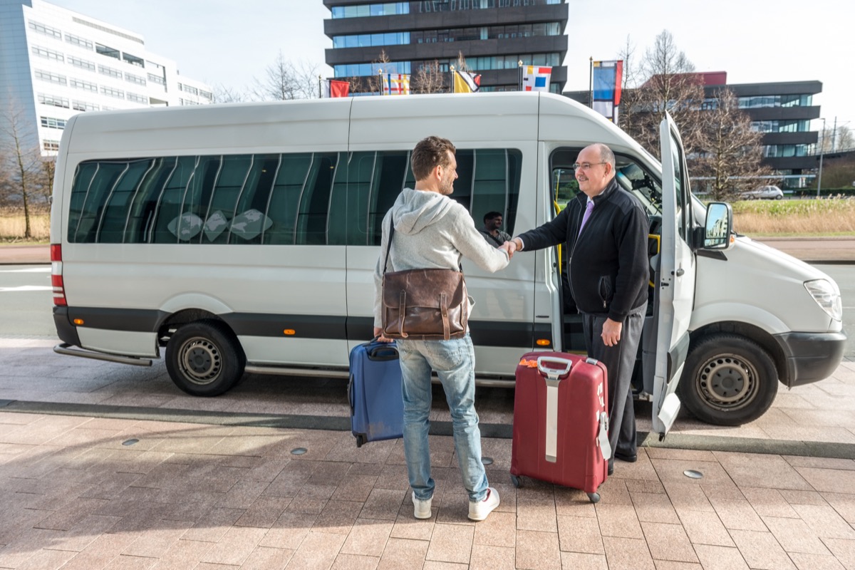 man meeting van driver outside airport