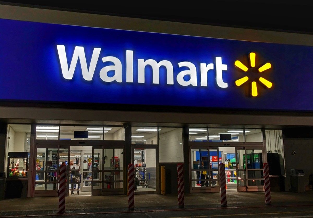 Walmart retailer storefront entrance sign, evening