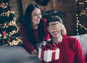 A woman surprising her husband with a holiday gift