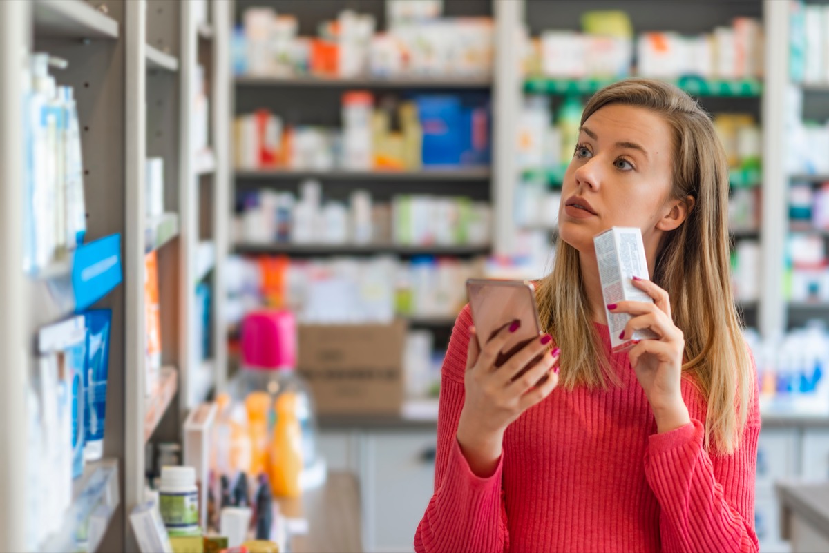 young woman buying supplements at a pharmacy