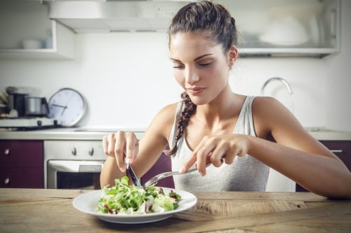 young woman cutting salad
